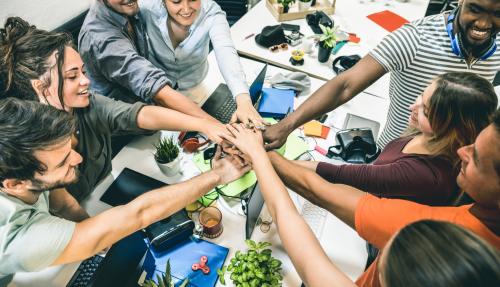 Group of people putting their hands in the middle 
