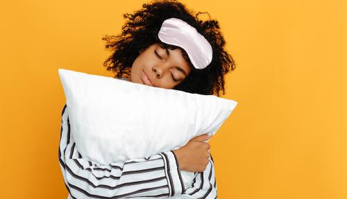 Female hugging and resting head on pillow